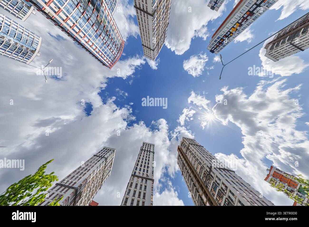 vue d'en bas dans le ciel bleu avec des nuages de grand complexe résidentiel de gratte-ciel moderne Banque D'Images