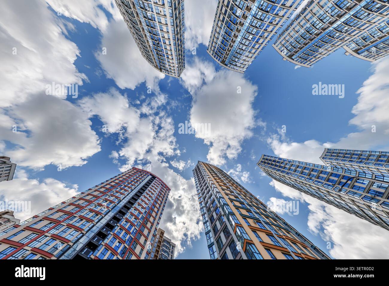 vue d'en bas dans le ciel bleu avec des nuages de grand complexe résidentiel de gratte-ciel moderne Banque D'Images