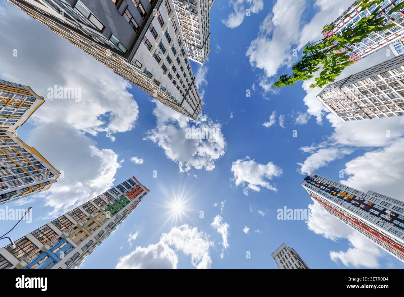 vue d'en bas dans le ciel bleu avec des nuages de grand complexe résidentiel de gratte-ciel moderne Banque D'Images