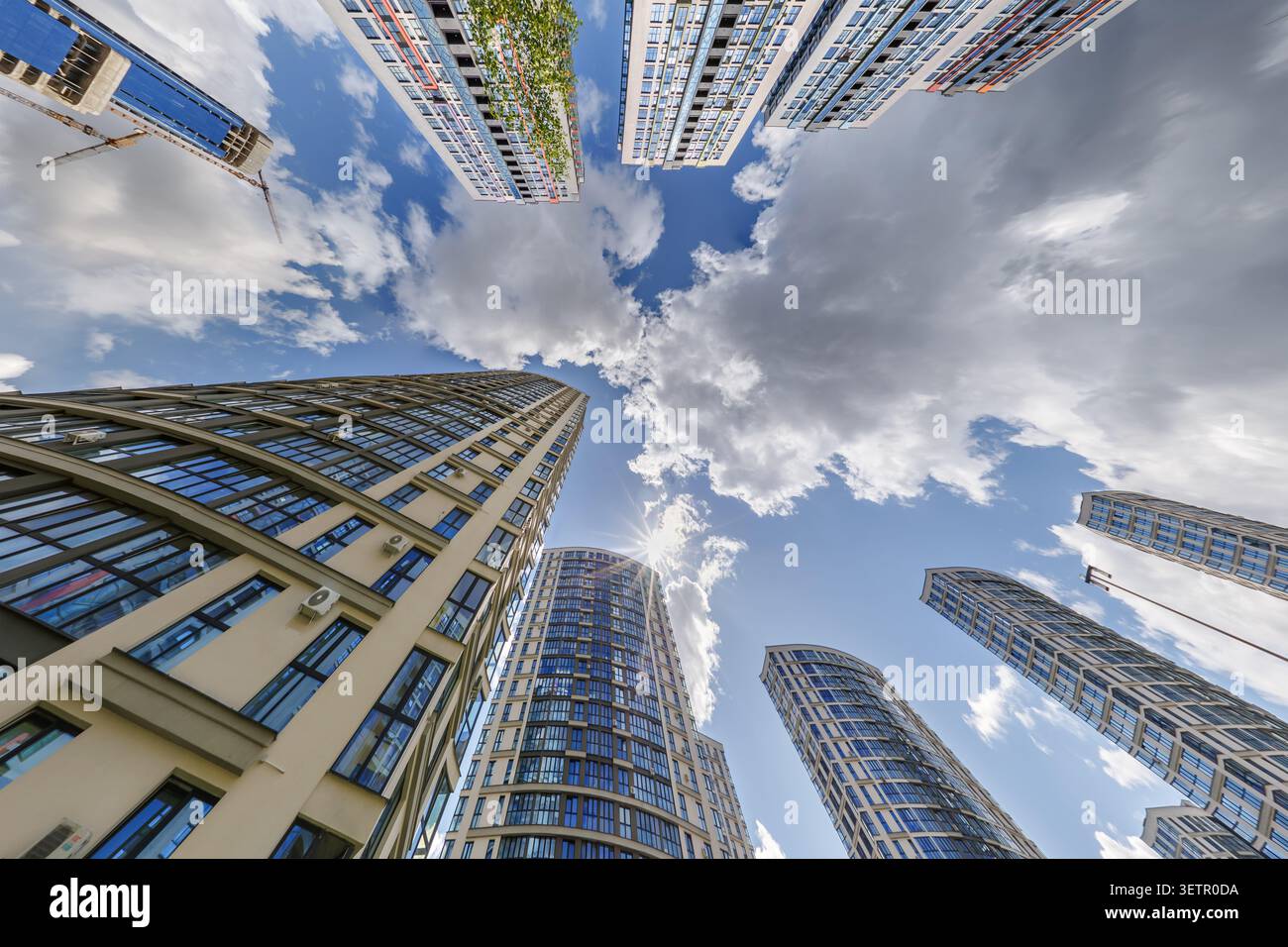 vue d'en bas dans le ciel bleu avec des nuages de grand complexe résidentiel de gratte-ciel moderne Banque D'Images