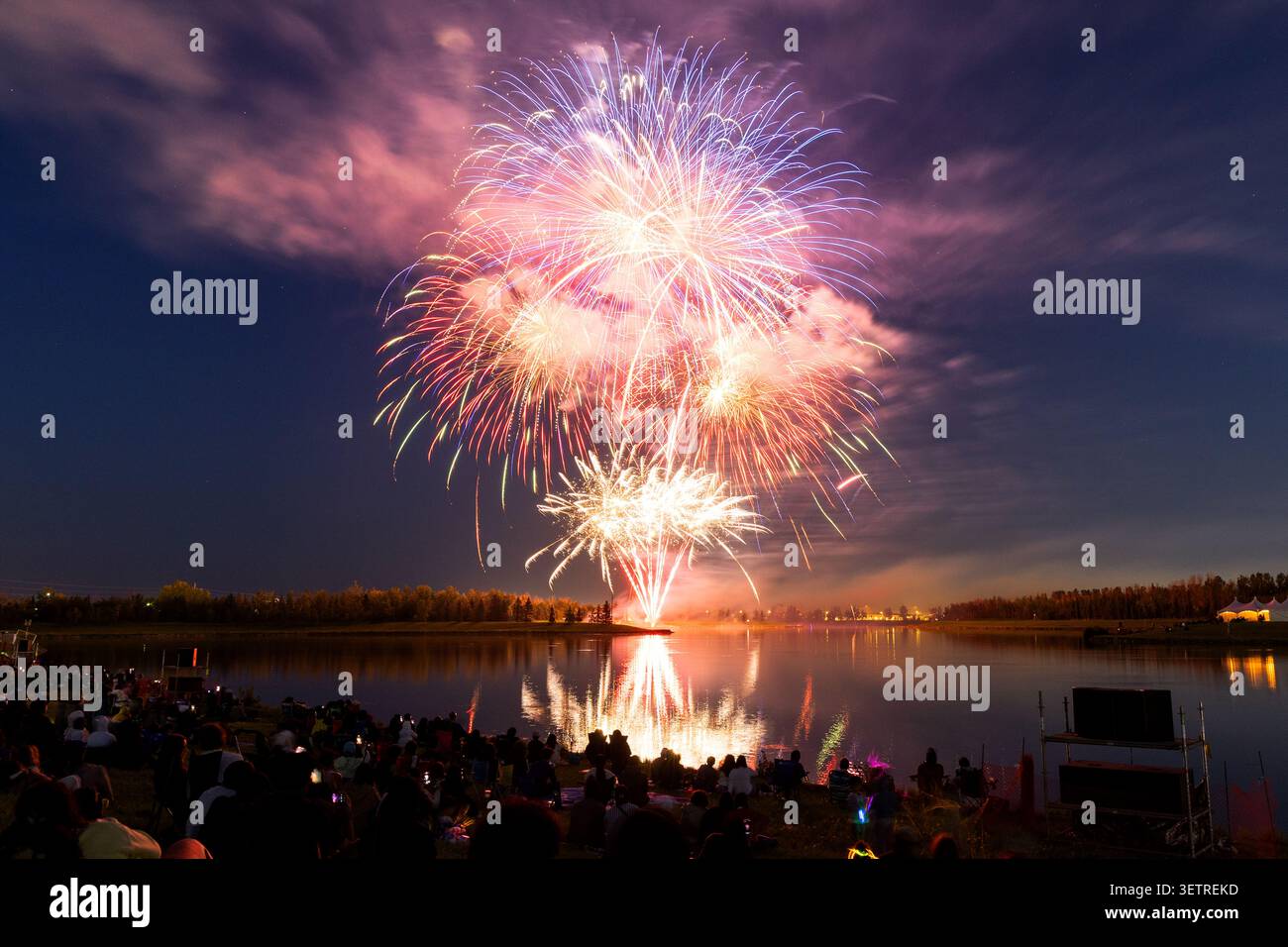 Les spectateurs regardent au loin sur l'eau pour admirer les feux d'artifice lors du festival annuel Global Fest à Calgary, Alberta, Canada. Banque D'Images