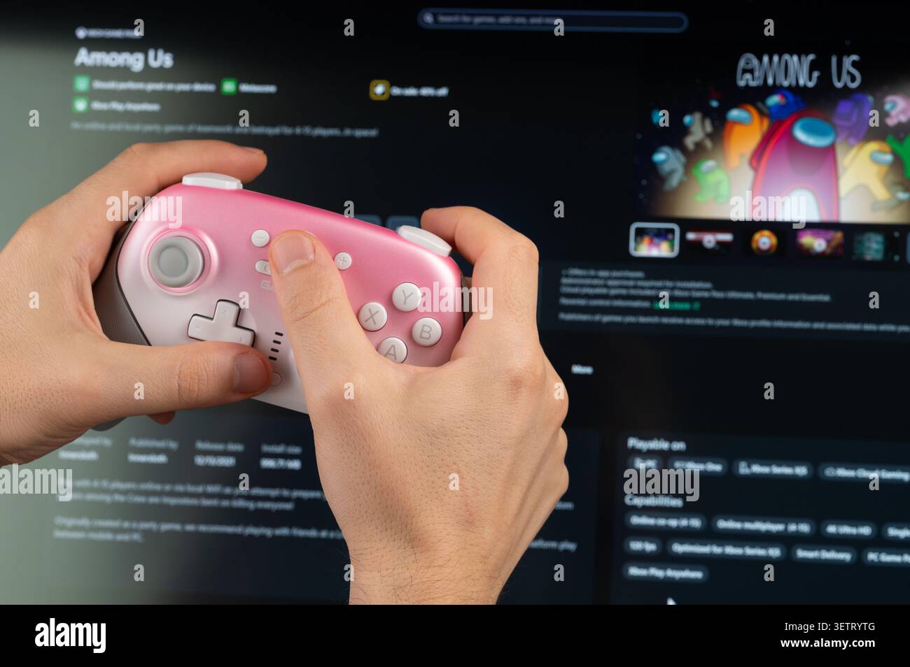 New York, États-Unis - 18 mai 2026 : jouer Among US jeu PC avec manette de jeu dans la main gros plan vue sur fond d'écran Banque D'Images