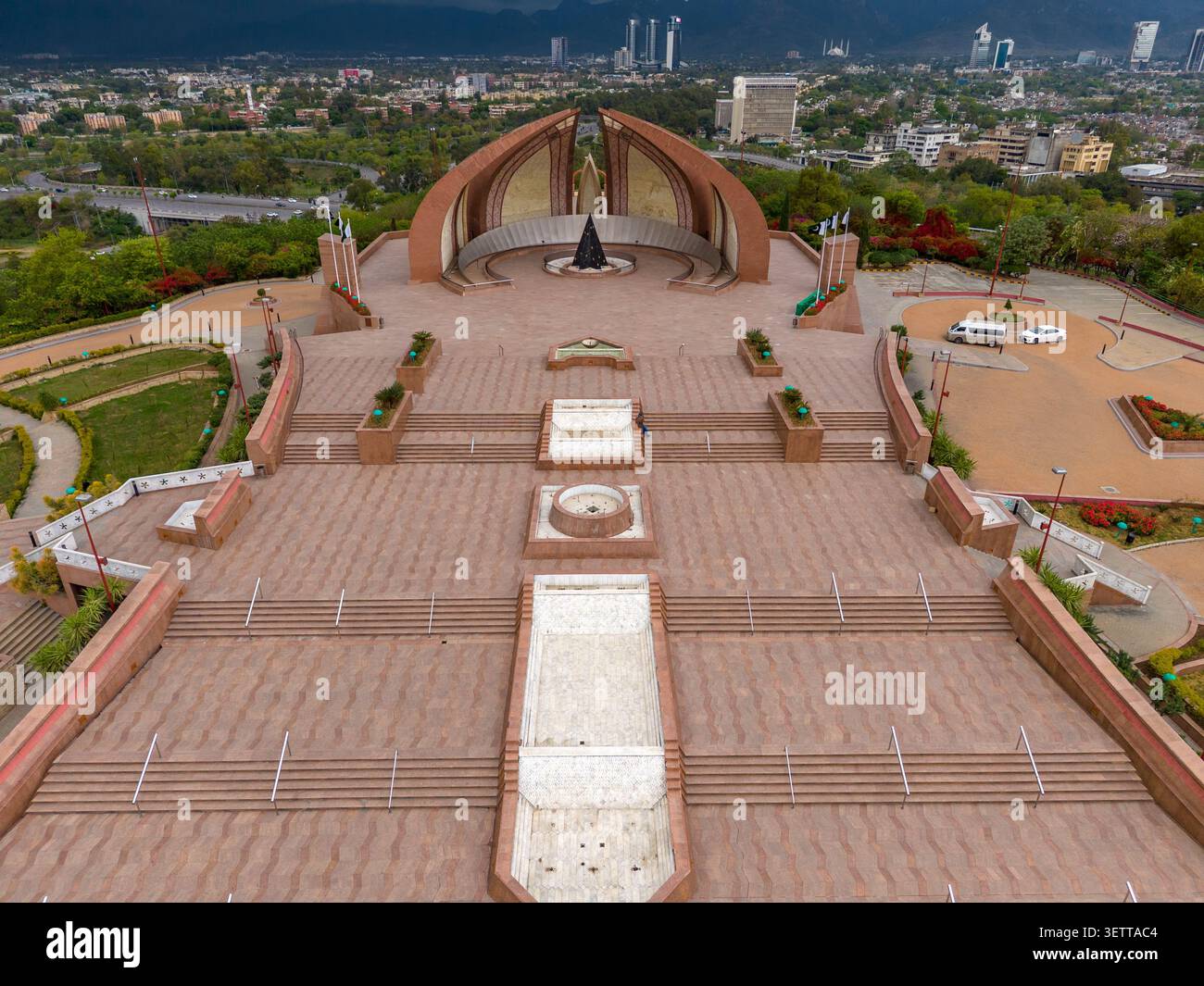 Vue aérienne du monument du Pakistan avec sa structure en pierre en forme de pétales distinctive, sa vaste place pavée et la verdure environnante à Islamabad, Banque D'Images