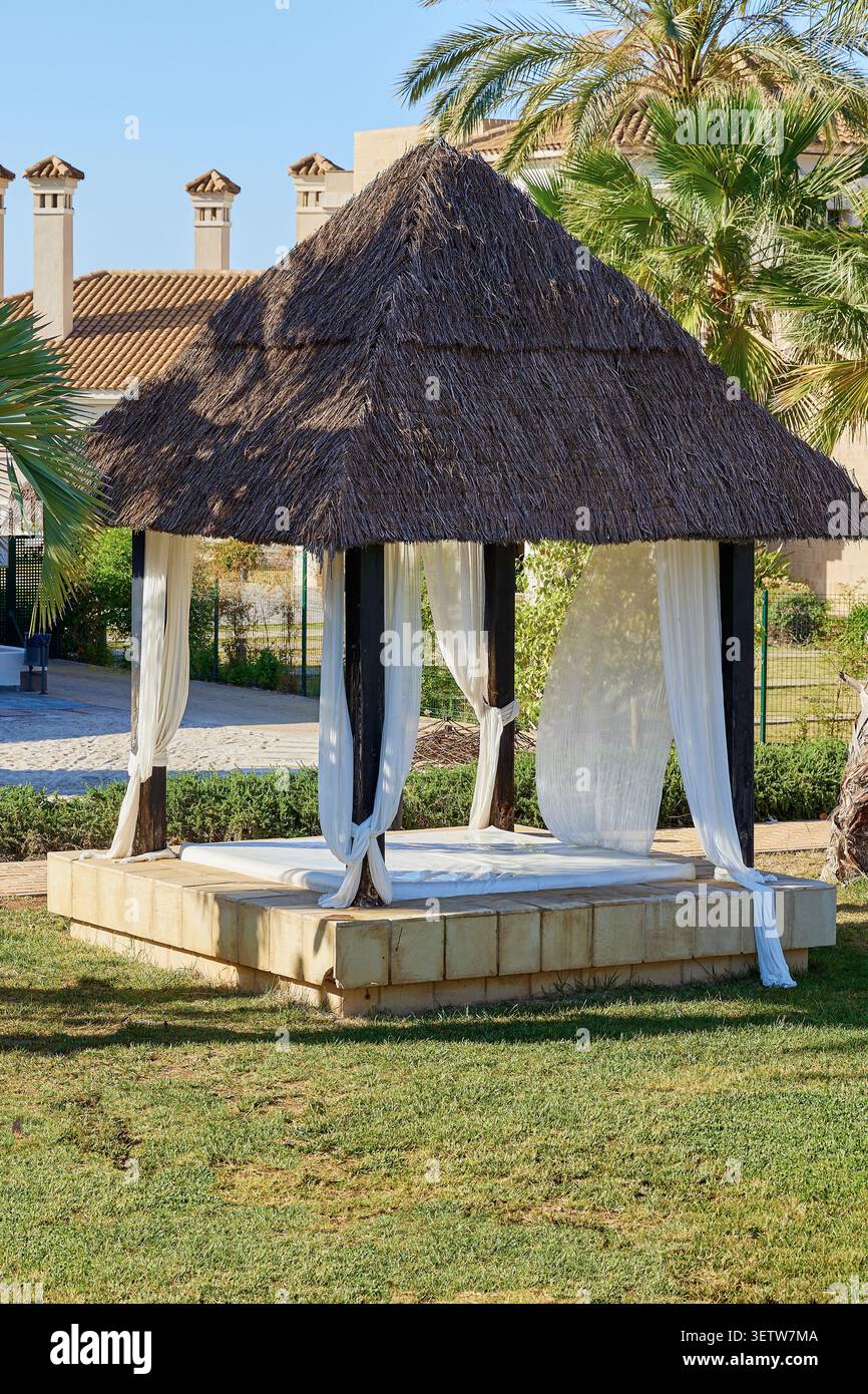 Gazebo avec une chaise longue sur une pelouse verte. Espagne. Banque D'Images