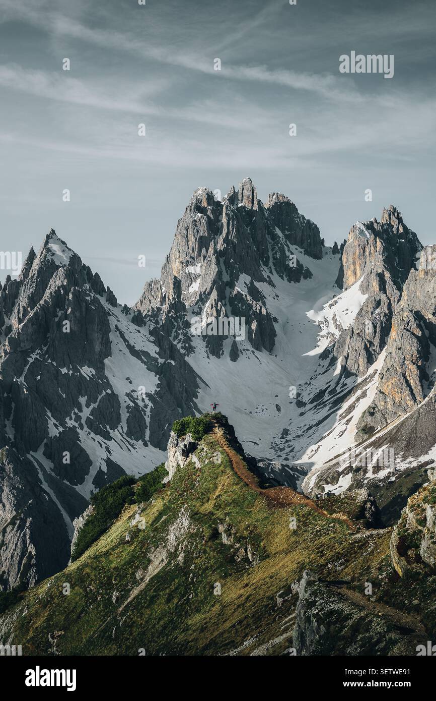 Auronzo di Cadore, Italie - 07 juin 2024 : vue sur les sommets déchiquetés de Cadini di Misurina avec un randonneur debout sur une crête étroite. Banque D'Images