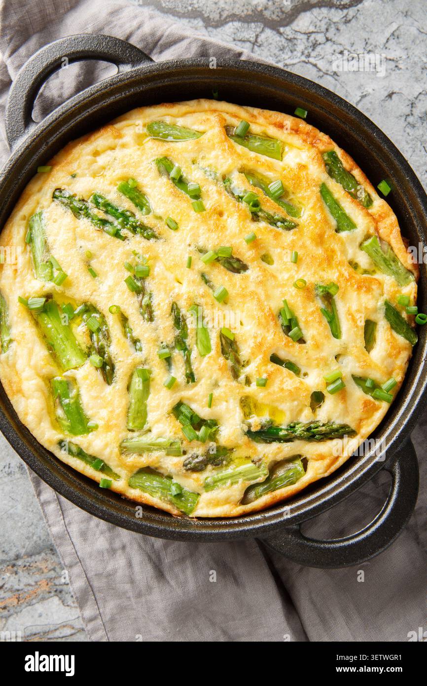 Italien Healthy Asperges omelette frittata gros plan dans la poêle sur la table. Vue de dessus verticale Banque D'Images