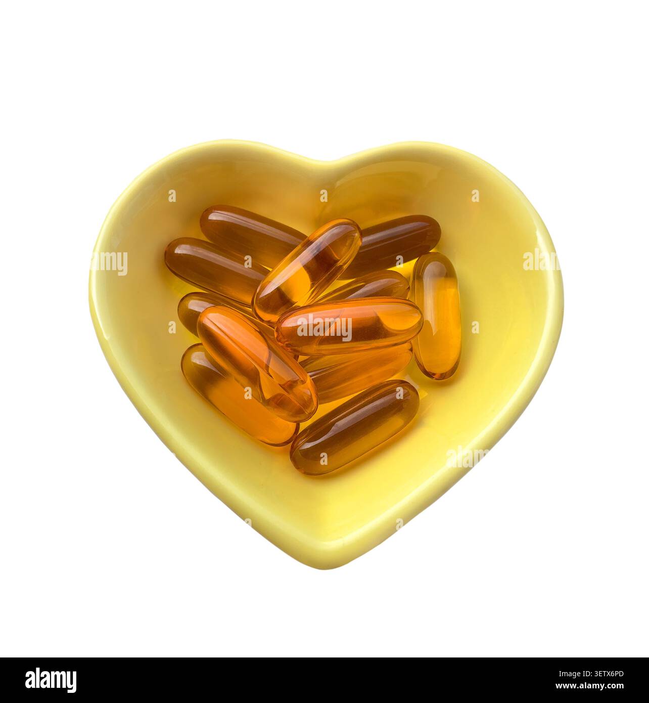 Plaque en forme de coeur jaune remplie de capsules de vitamine, compléments alimentaires isolés sur fond blanc. Santé, bien-être, nutrition, Lif sain Banque D'Images