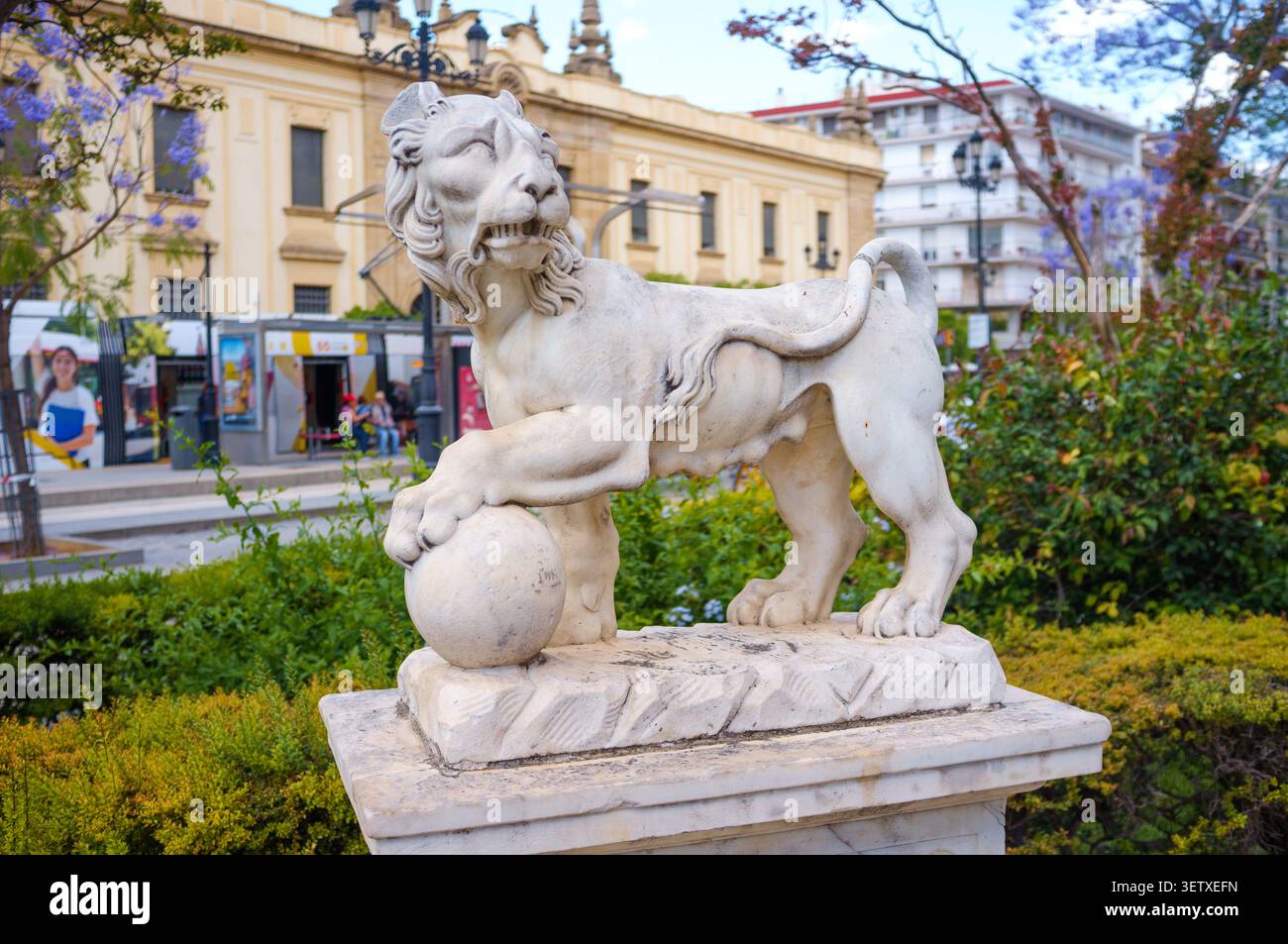 Une sculpture de lion blanc fantaisiste dans le style des sculptures de lion des Médicis dans le jardin de l'Archive générale des Indes à Séville, Espagne. Banque D'Images
