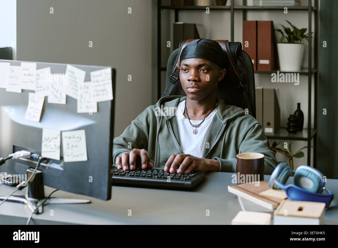 Homme noir travaillant à l'ordinateur de bureau dans le bureau Banque D'Images