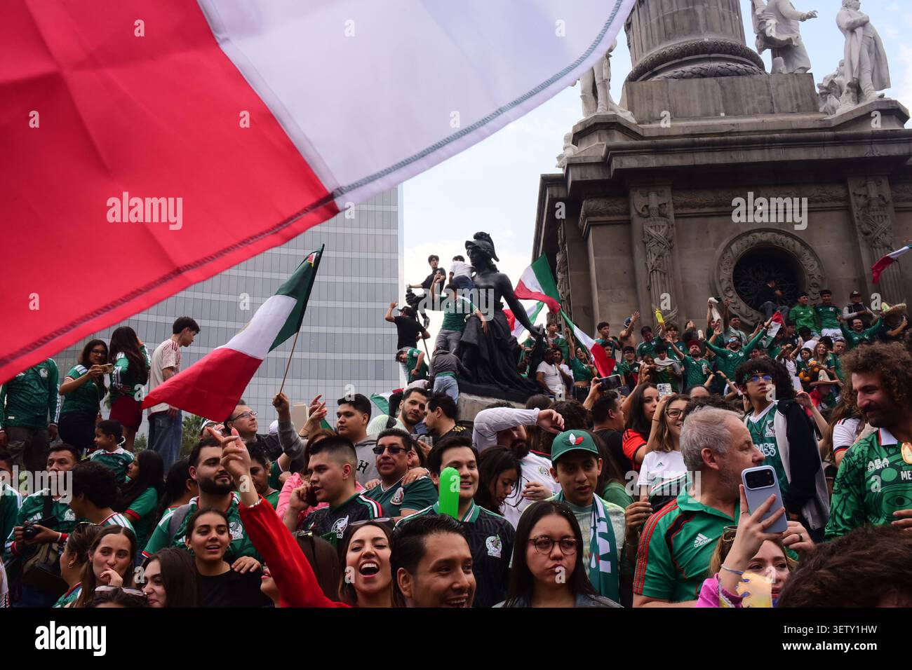 Les fans mexicains grimpent sur les statues de l'Ange de l'indépendance agitant des drapeaux pendant la célébration de la Coupe du monde. Banque D'Images