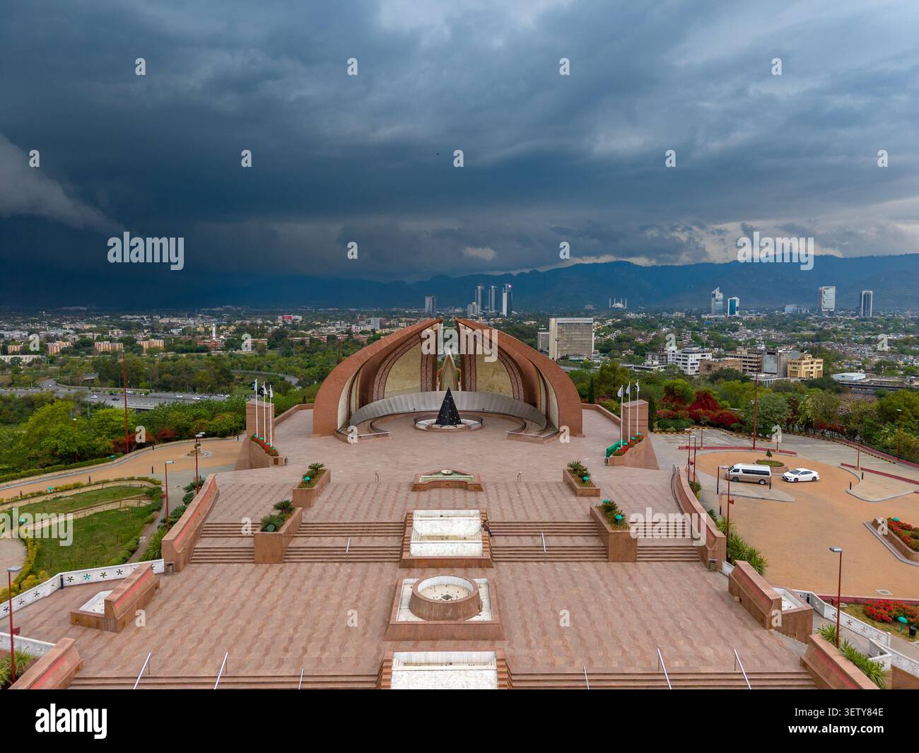 Vue aérienne du Monument du Pakistan avec sa structure en forme de pétales et sa place en pierre, entourée de verdure et de l'horizon de la ville à Islamabad, Islama Banque D'Images