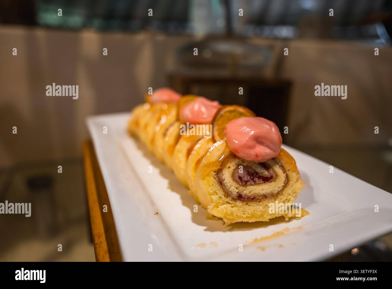 Pain suisse tranché avec confiture de baies et agrumes sur plateau blanc Banque D'Images