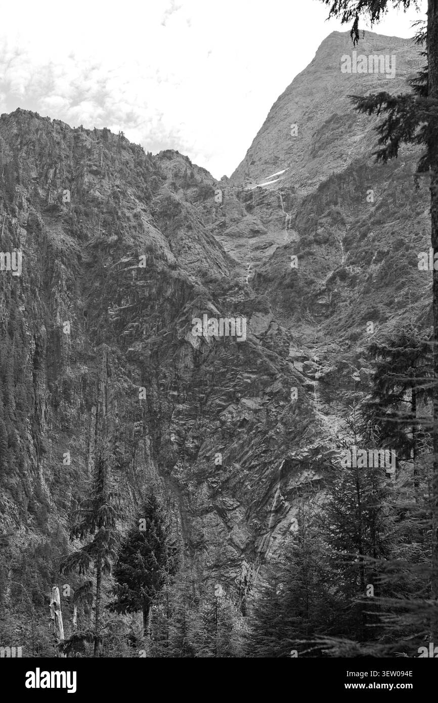 falaises rocheuses abruptes et une cascade étroite traversant un terrain alpin accidenté. Banque D'Images