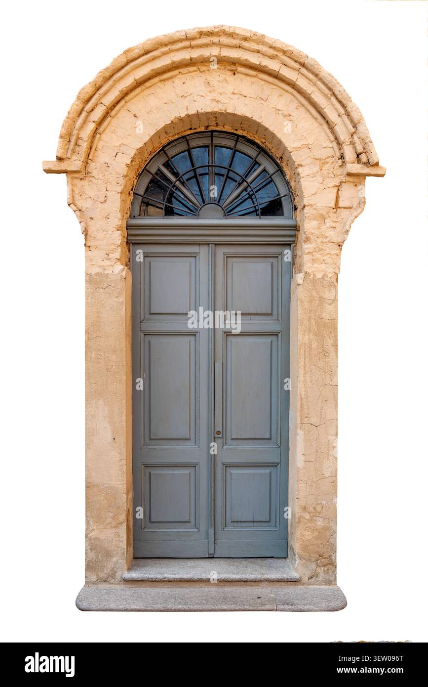 Vieille porte double en bois gris avec une élégante fenêtre de tableau arrière cintré et une grille en fer forgé en forme d'éventail, encadrée par une brique et des plas traditionnels altérés par les intempéries Banque D'Images