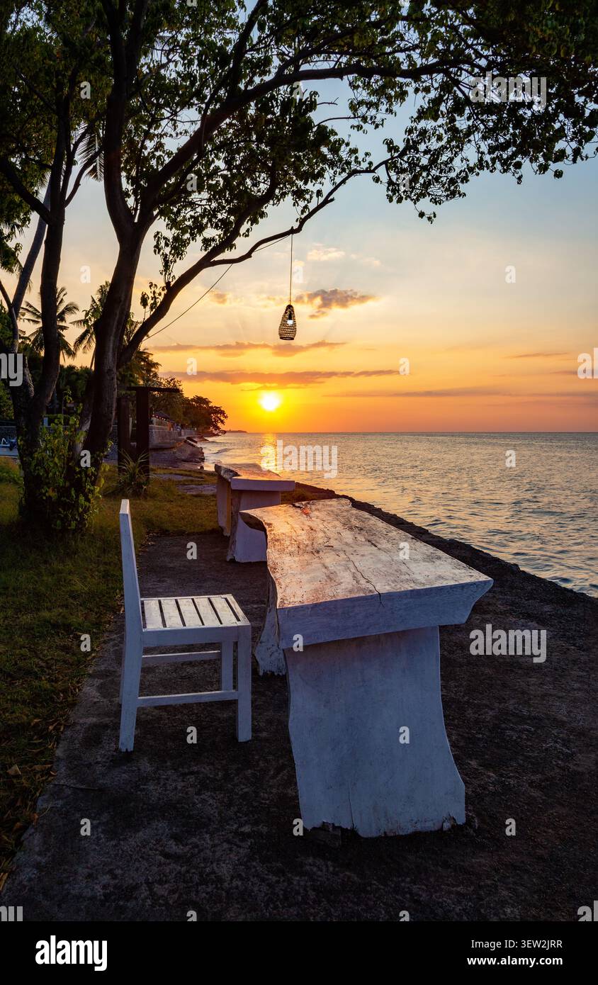 Table et chaise au bord de la mer, Bali, Indonésie, Asie du Sud-est. Table et chaise pour la détente au coucher du soleil, Bali, Indonésie. Banque D'Images