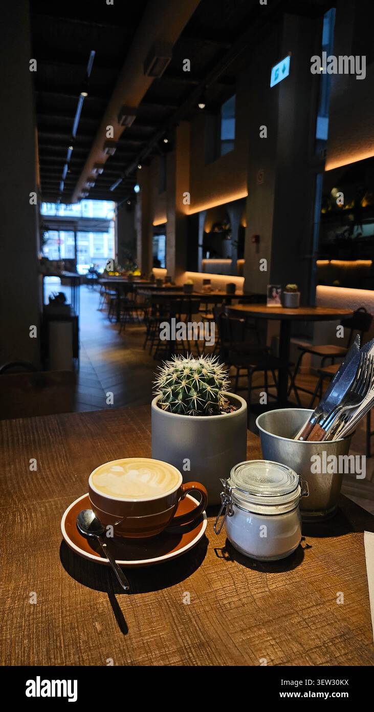 Café cappuccino servi dans un café moderne décoré d'un intérieur chaleureux - Image de stock capturée avec un smartphone