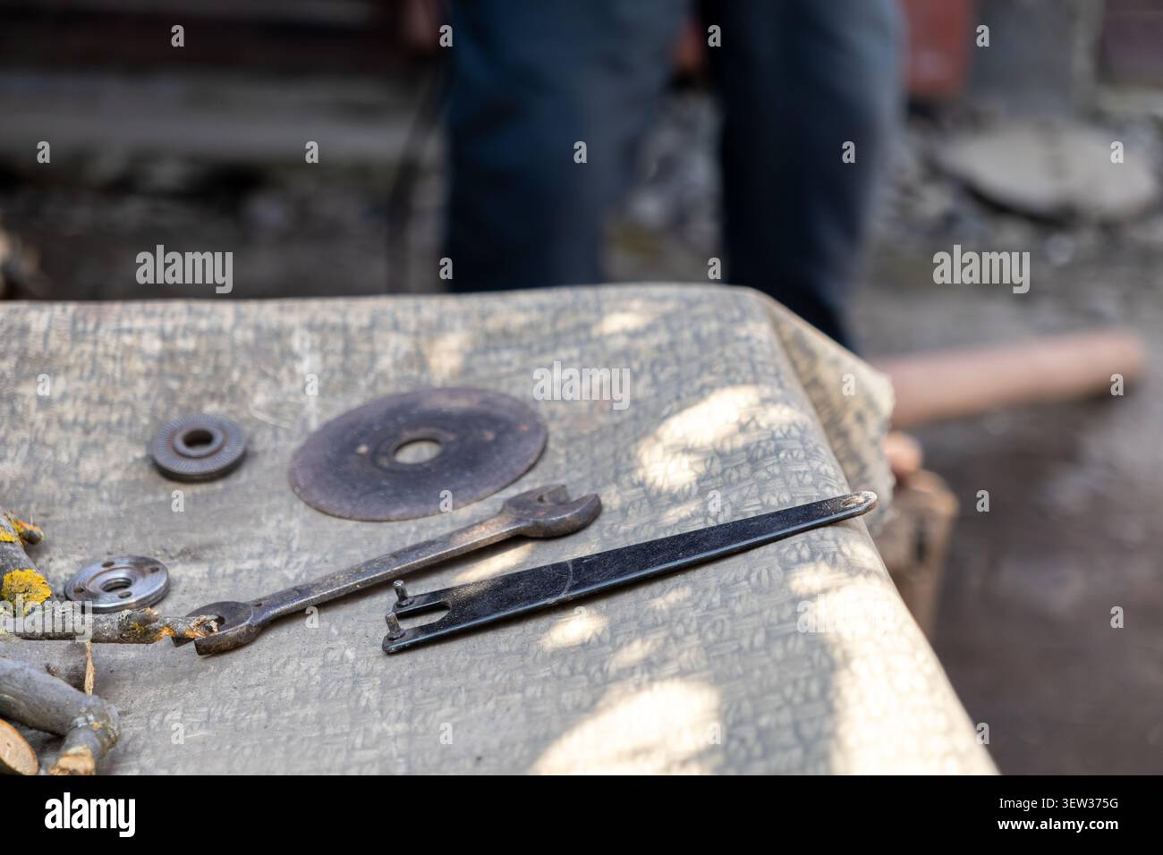 Disque à tronçonner en métal essentiel et clé à ergots disposés sur une surface robuste, illustrant la préparation technique pour les tâches mécaniques, matériel Banque D'Images