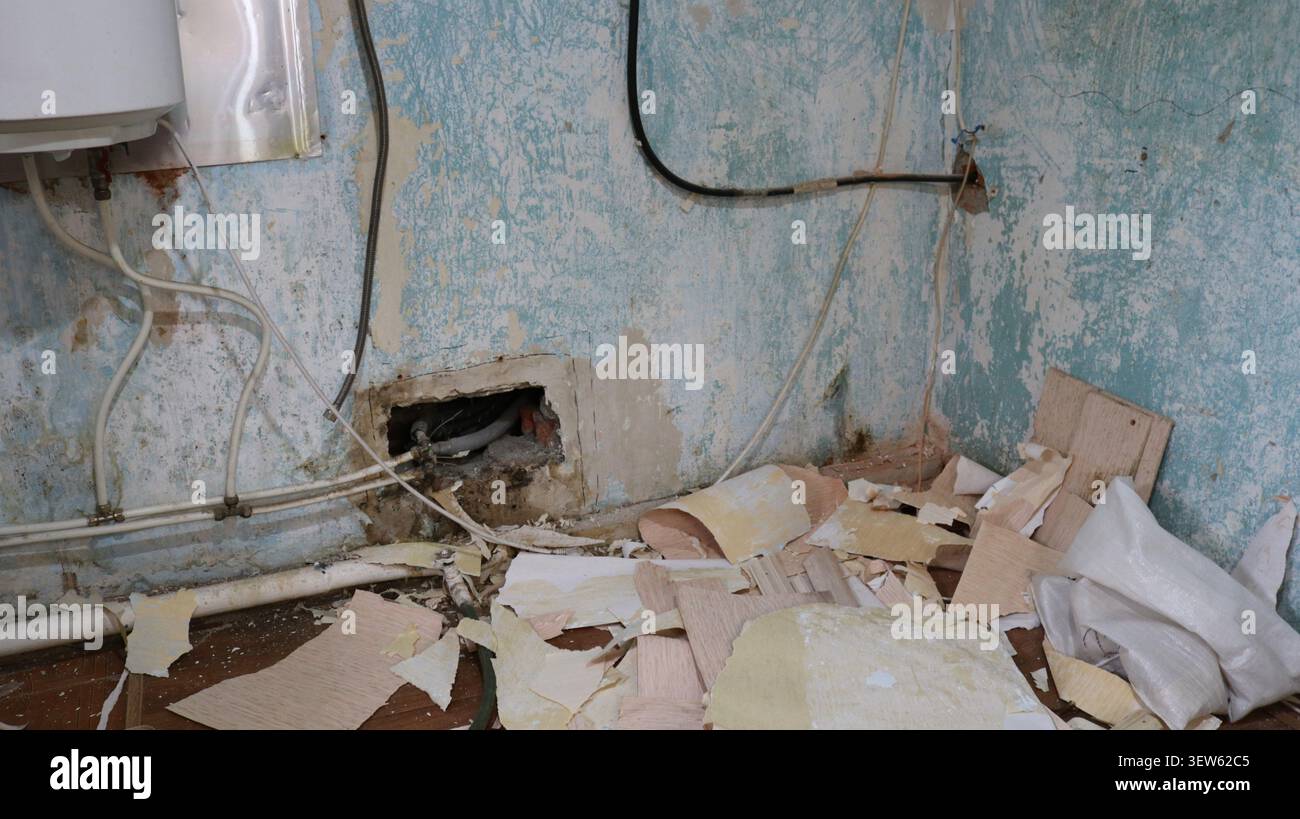 La chaufferie a besoin d'une rénovation majeure. La peinture endommagée doit être enlevée, le papier peint doit être enlevé et les tuyaux endommagés doivent être remplacés. Banque D'Images