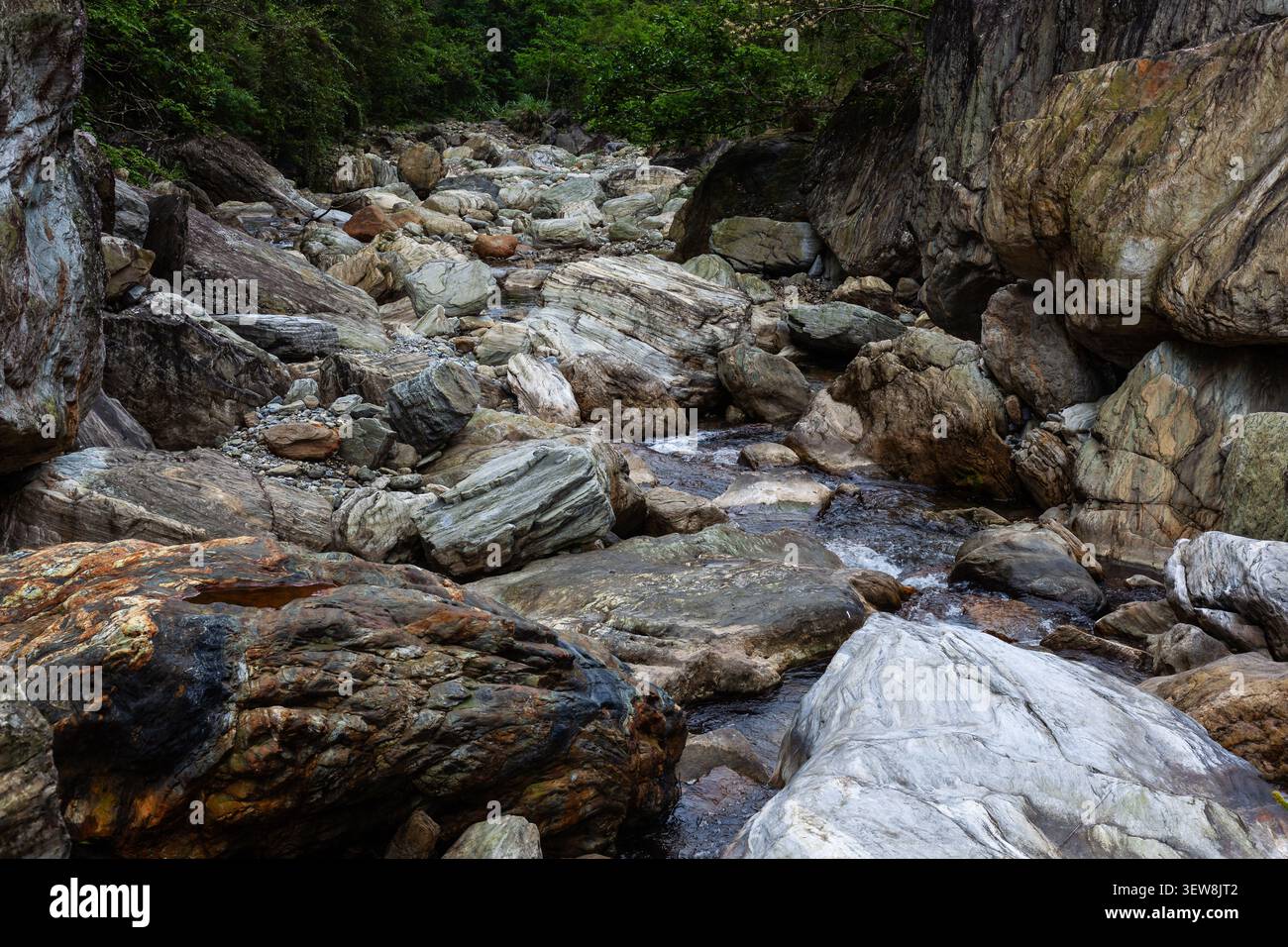 Lit de la rivière Sanzhanxi à Taroko, Taiwan. De grands rochers de marbre remplissent la gorge rocheuse. Un petit ruisseau coule à travers le paysage montagneux. Banque D'Images