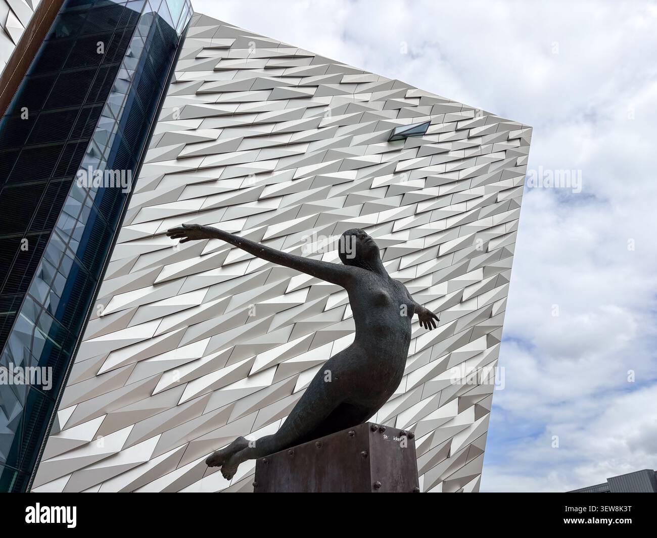 Sculpture de la déesse de la mer devant la façade géométrique du musée Titanic Belfast. Titanic Quarter, Belfast, Irlande du Nord. Banque D'Images
