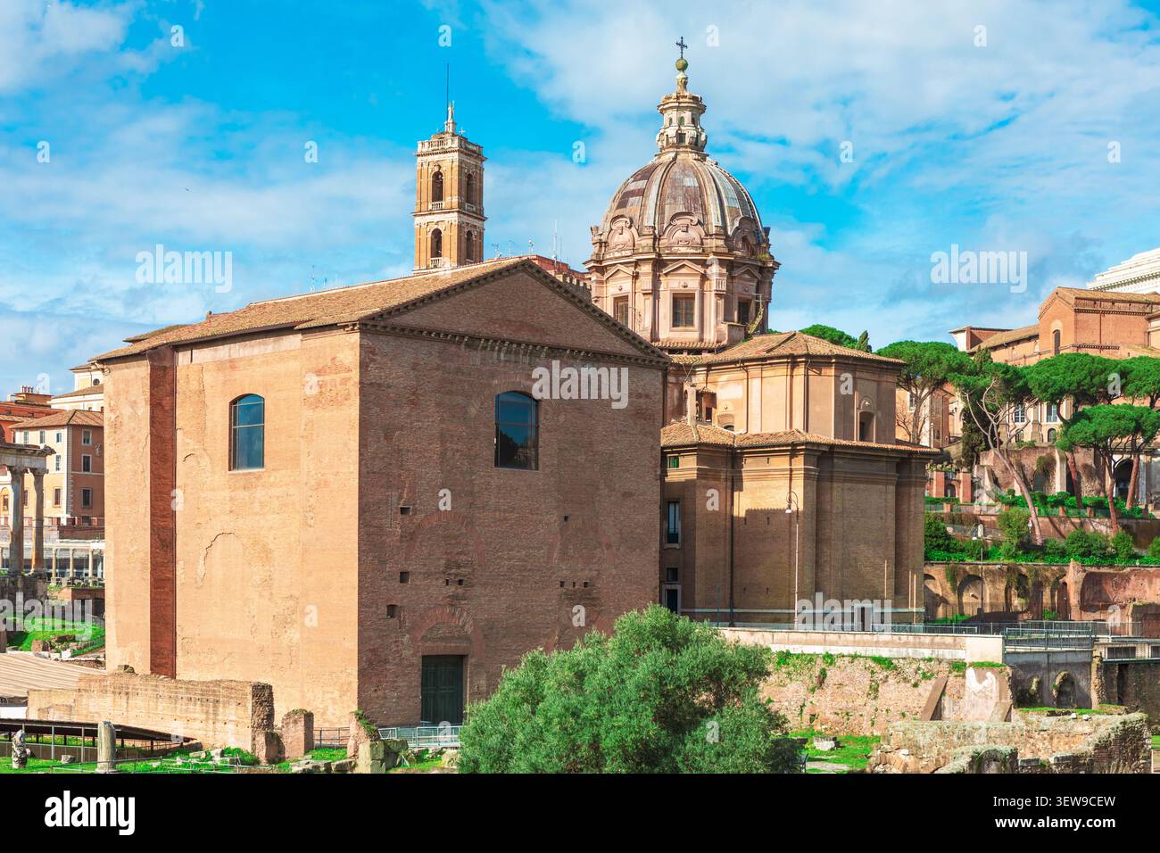 Le Forum romain présente l'ancienne brique Curia Julia debout en évidence au premier plan. Derrière cette maison du Sénat se dresse la magnifique église en dôme de Santi lu Banque D'Images