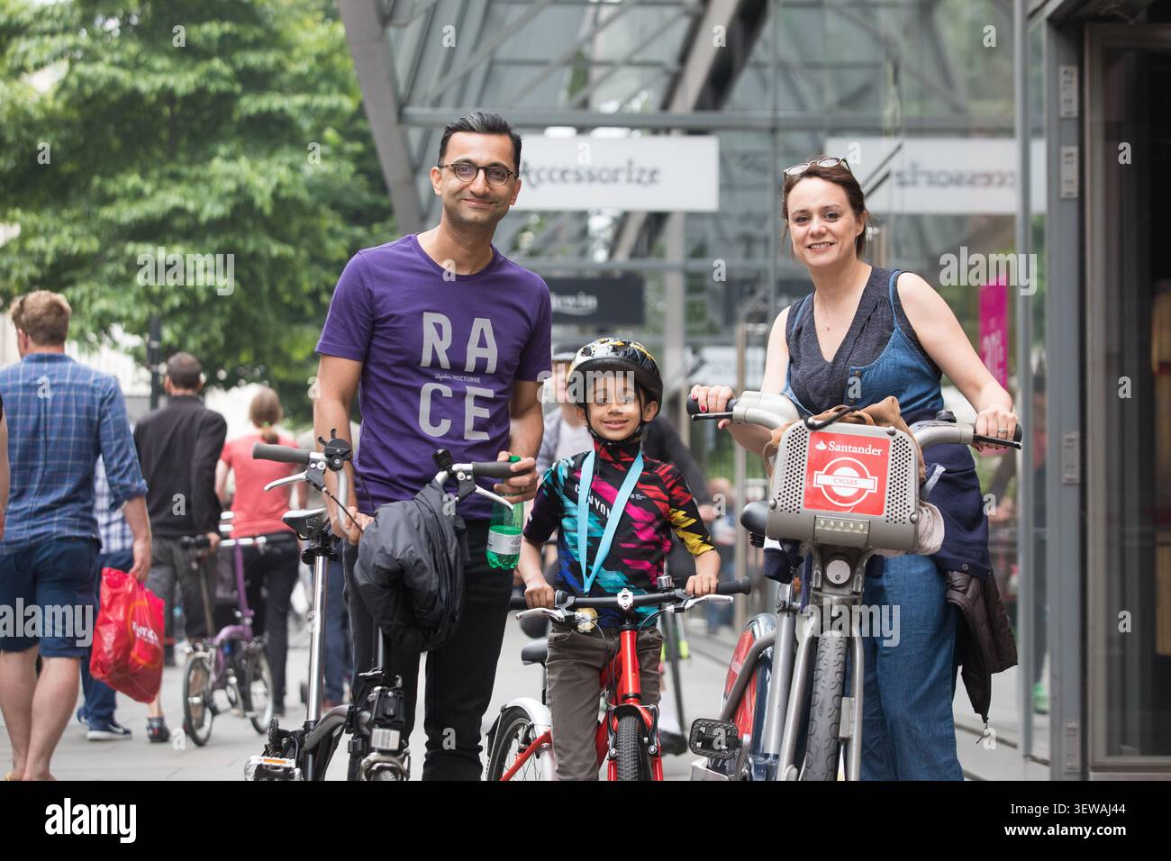 Une famille célèbre après une course au London nocturne, qui a lieu devant le centre commercial One New change dans la City de Londres. Banque D'Images