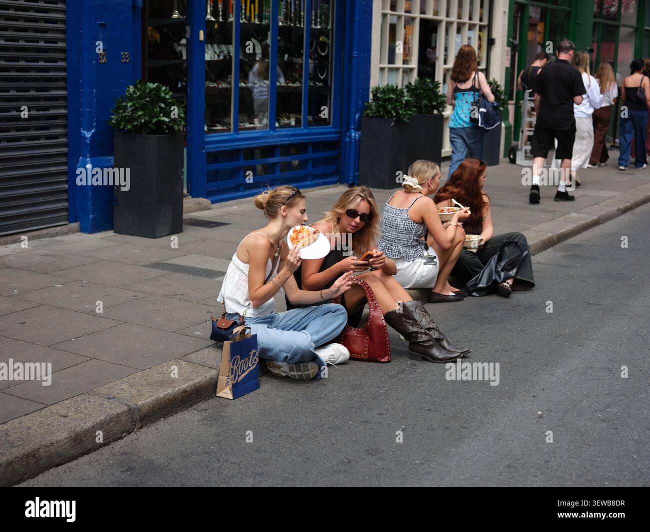 Deux jeunes filles étaient assises dans la rue en mangeant de la pizza sur Drury Street dans la ville de Dublin, en Irlande. Banque D'Images