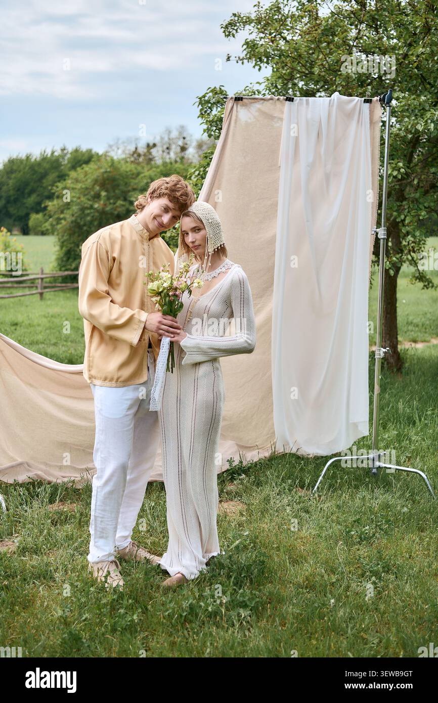 Couple élégant profite d'un moment tendre ensemble tout en étant entouré par la nature Banque D'Images