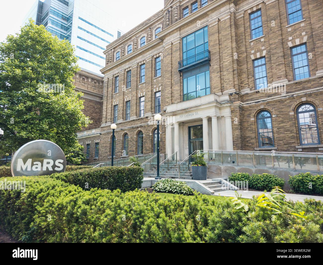 Le bâtiment historique du quartier de découverte MaRS se dresse sur College Street à Toronto, avec des fenêtres en arc, une architecture en brique et un MaRS proéminent - Image de stock capturée avec un smartphone