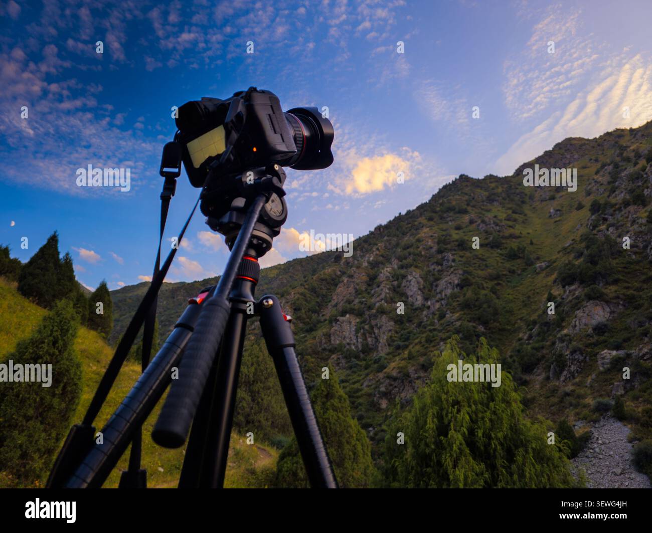 Appareil photo monté sur trépied capturant le paysage de montagne pittoresque sous le ciel dramatique, la photographie en plein air et le concept de voyage Banque D'Images