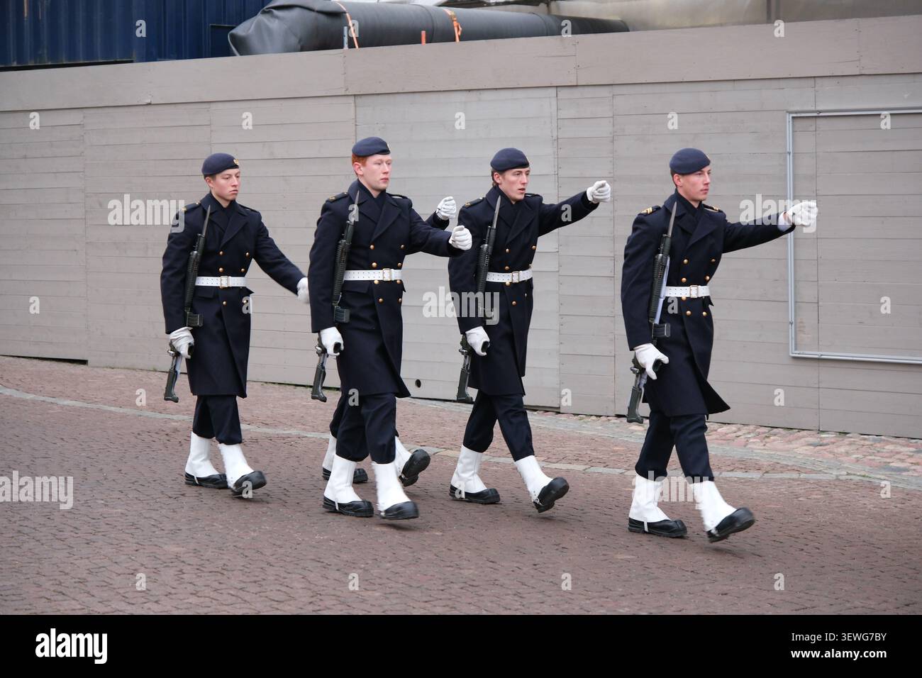 Stockholm, Suède-Nov.27th 2025 : gardes royales en manteaux militaires bleu foncé et bérets marchant vers l'avant lors d'une cérémonie de relève de la garde Banque D'Images