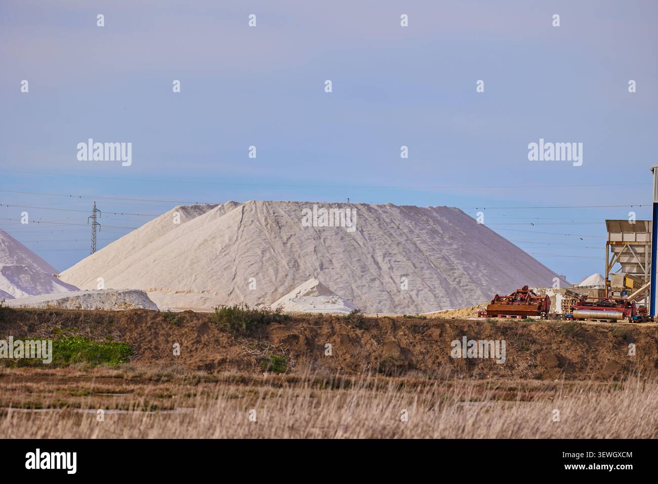 Cadix, Espagne - 06 janvier 2024 : exploitation du sel dans la banlieue de Cadix. Montagnes de sel préparées pour le chargement. Industrie du sel. Banque D'Images