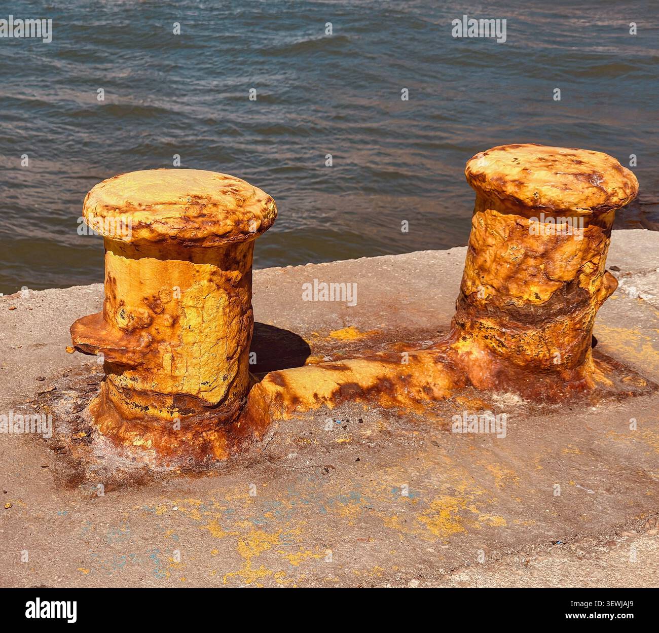 Bornes de port rouillées et poteaux d'amarrage sur une jetée en béton au bord de la mer en Grèce - Image de stock capturée avec un smartphone