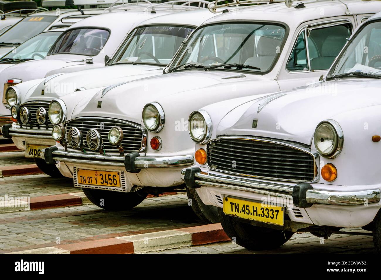 INDE, CHENNAI - 24 juin 2016 : un gros plan, à hauteur des yeux, capture l'avant de quatre voitures blanches de l'Hindustan Ambassador garées en diagonale, leur Banque D'Images