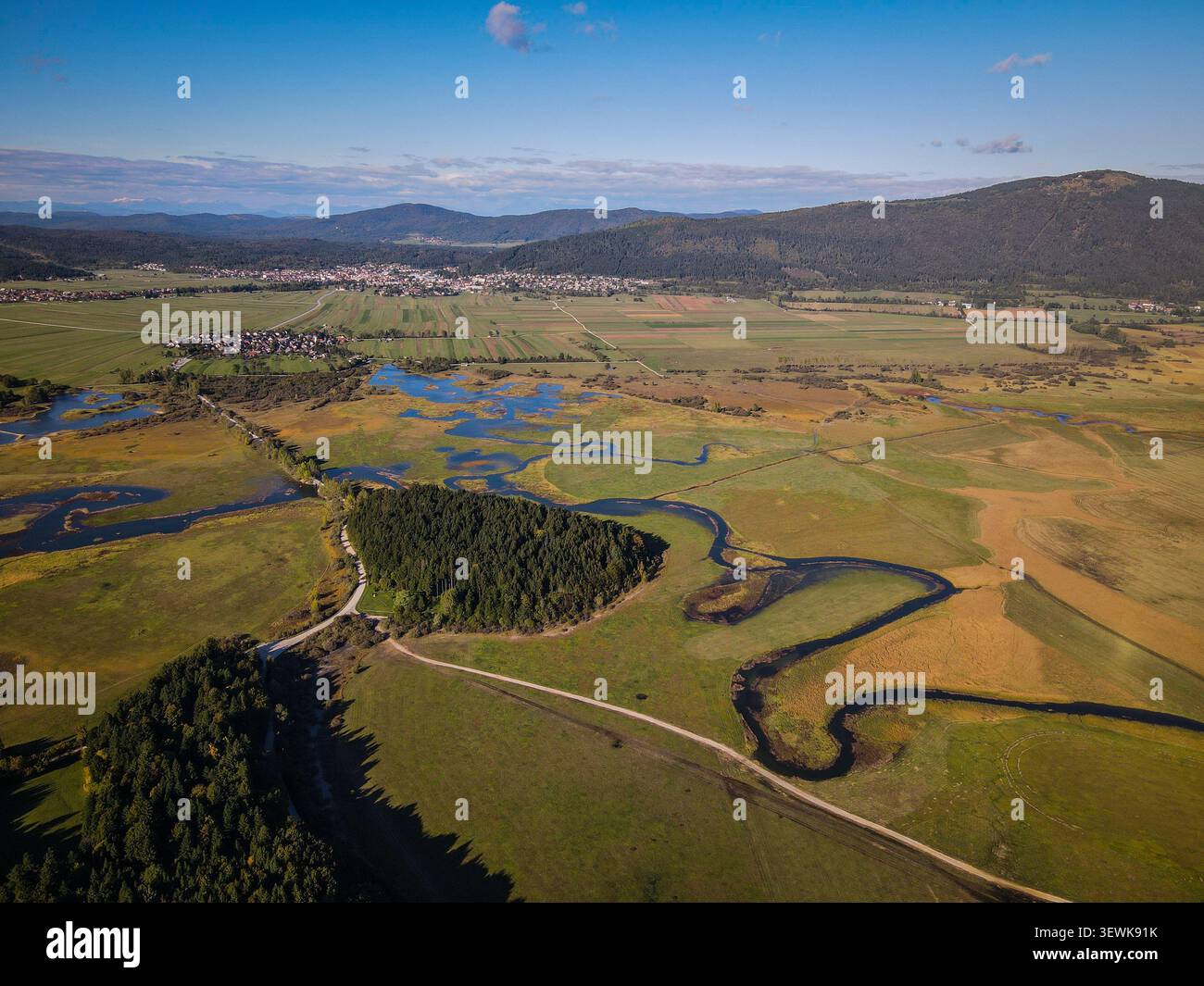 SLOVÉNIE, CERKNICA - 14 octobre 2021 : une vue aérienne montre une rivière sinueuse, des champs verts et dorés, une forêt dense et plusieurs petites villes avec Hou Banque D'Images