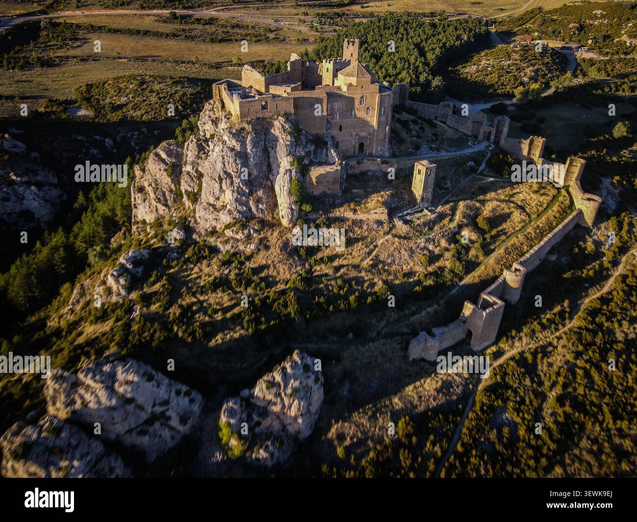 Le château de Loarre, une forteresse romane, est situé sur un éperon rocheux entouré de broussailles et de forêts au premier plan et en arrière-plan. Ce drone s Banque D'Images