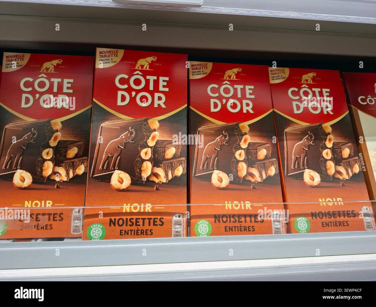 AVIGNON, FRANCE - 31 octobre 2025. Les barres de chocolat noir Côte d’Or avec des noisettes entières sont soigneusement disposées sur une étagère dans une station-service en Provence Banque D'Images