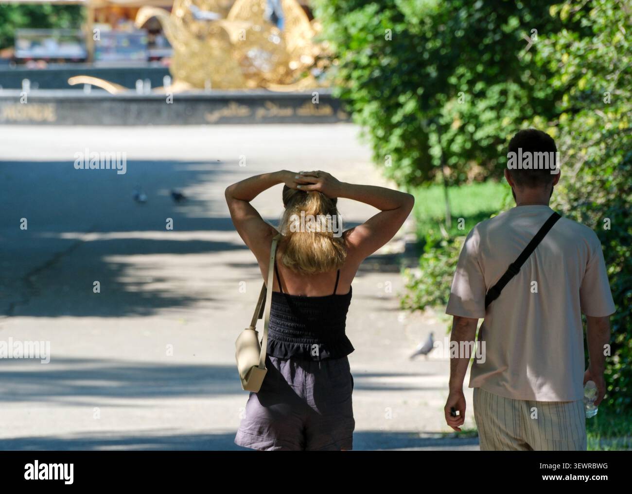 KIEV, UKRAINE - 28 JUIN 2026 : vue arrière d'un jeune homme et d'une jeune femme marchant le long d'un chemin ombragé dans le jardin botanique national M. M. Gryshko. L'annonce femme Banque D'Images