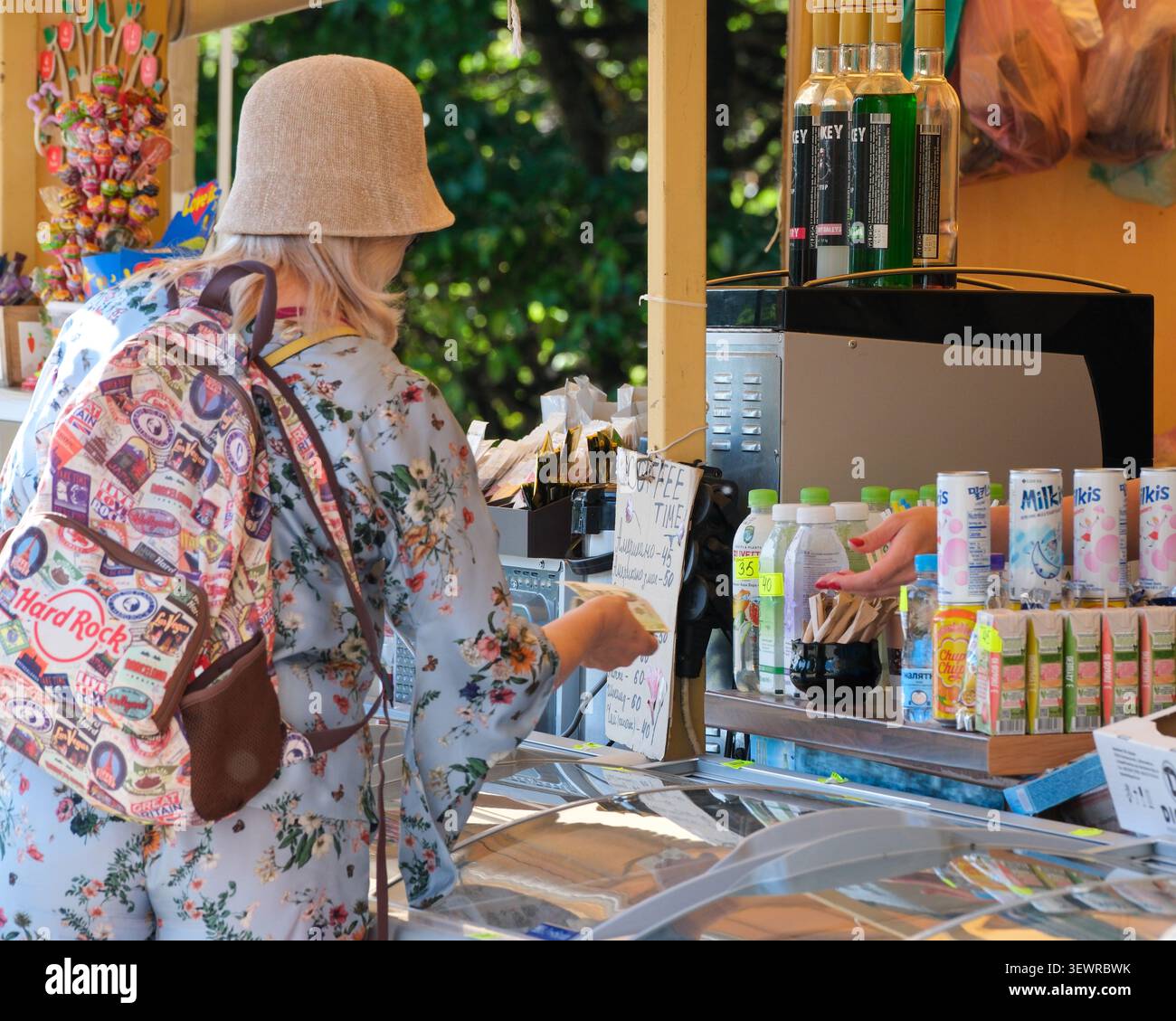 KIEV, UKRAINE - 28 JUIN 2026 : vue arrière d'une femme portant un sac à dos alors qu'elle achetait des boissons et des collations dans un kiosque de rafraîchissements à M. M. Gryshko National Banque D'Images
