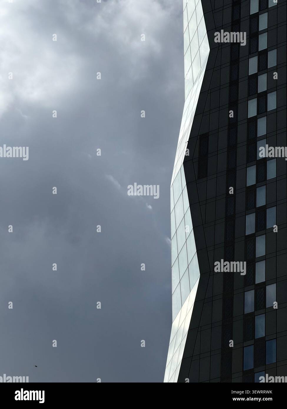 Détail du nouveau bloc de tour partie du complexe Deansgate Square dans le centre de Manchester avec le soleil attrapant dans les fenêtres contre les nuages sombres - Image de stock capturée avec un smartphone