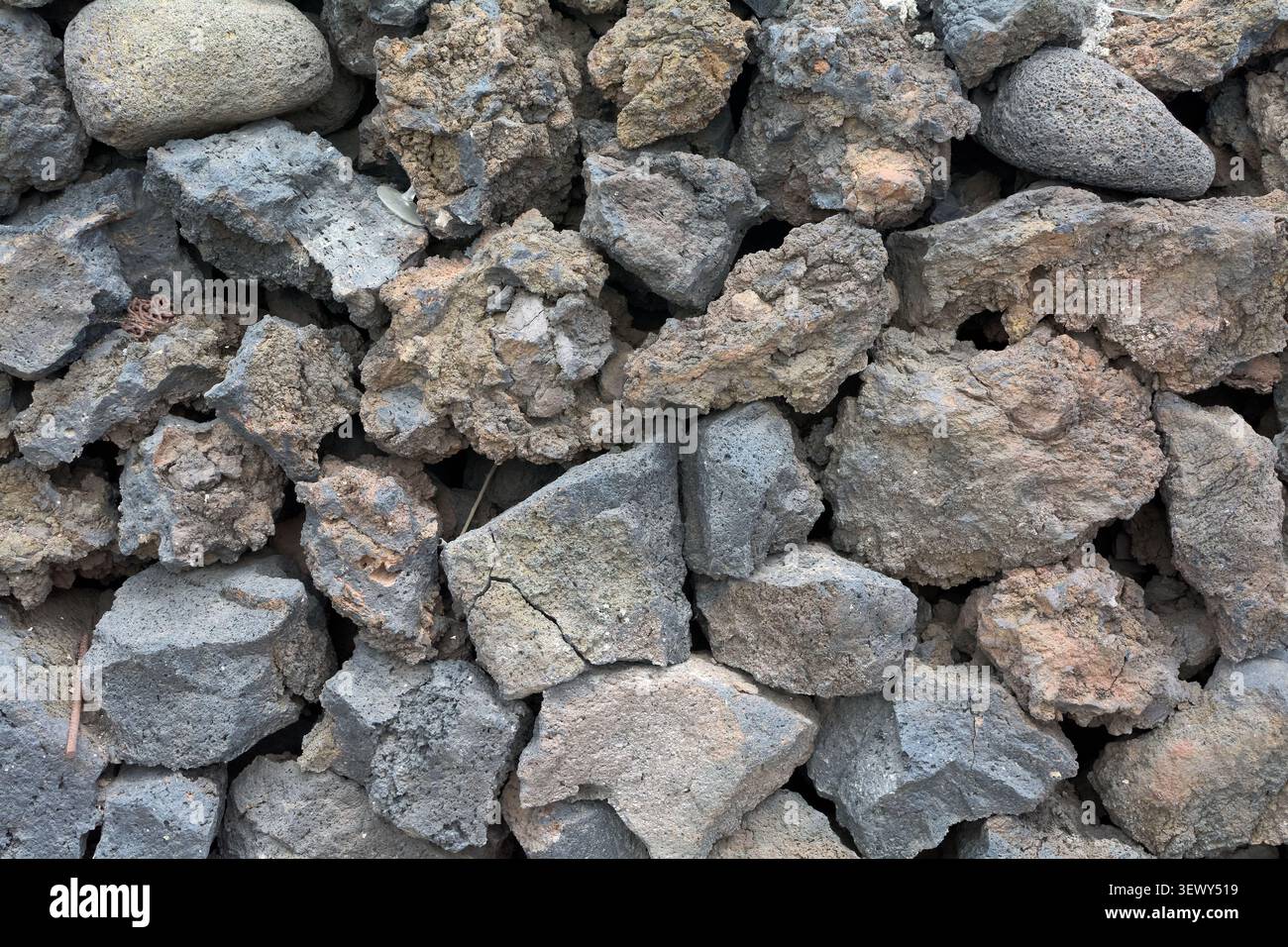 Gros plan détaillé d'un mur de pierre texturé construit à partir de roches volcaniques rugueuses, gris foncé et brunes à Agaete. Banque D'Images