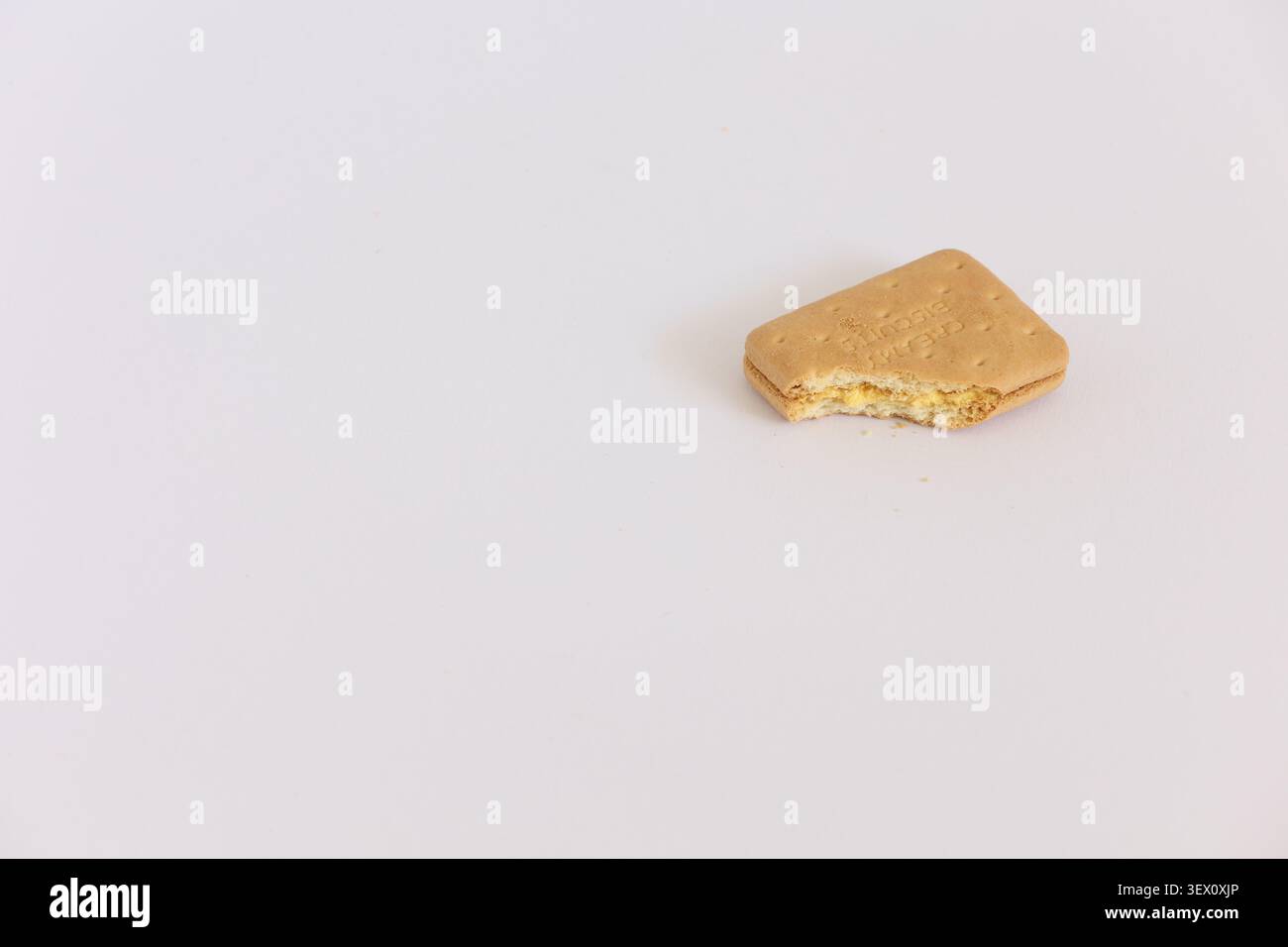 Bitten Sandwich Cookie avec remplissage de crème sur fond blanc collation minimale avec miettes photographie Banque D'Images