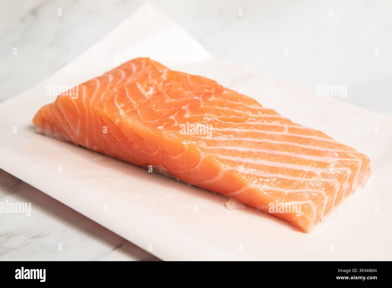 Le poisson frais est posé sur du papier dans une cuisine. Il est prêt à être préparé. Banque D'Images