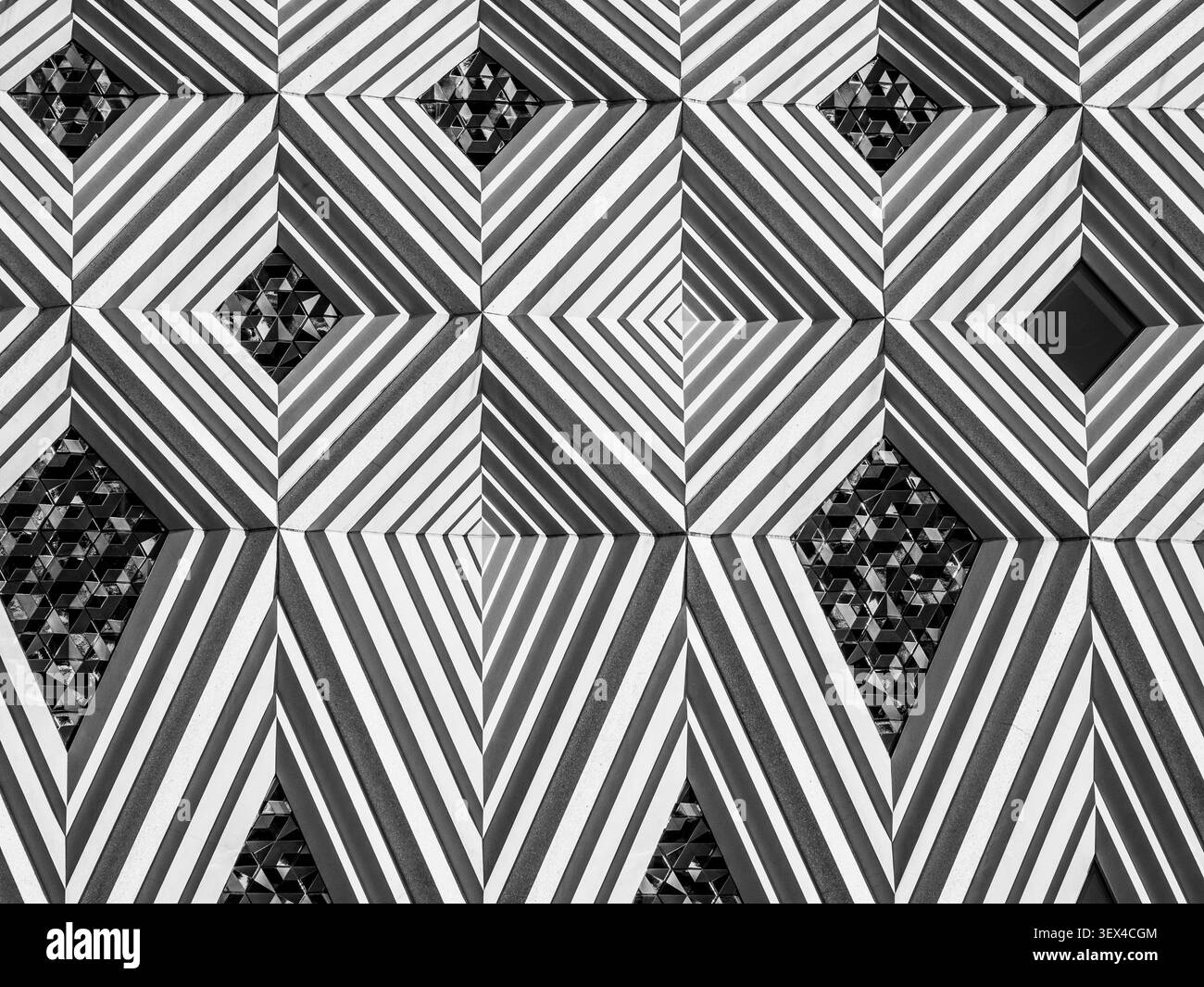 Panneaux de façade géométriques formant des motifs en losange avec des surfaces rayées à travers le bâtiment Banque D'Images