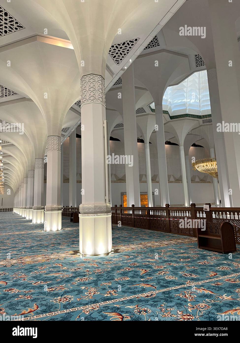 Vue large sur l'intérieur élégant de la Grande Mosquée avec de hautes colonnes lumineuses, tapis luxueux, arches islamiques, détails architecturaux complexes - Image de stock capturée avec un smartphone