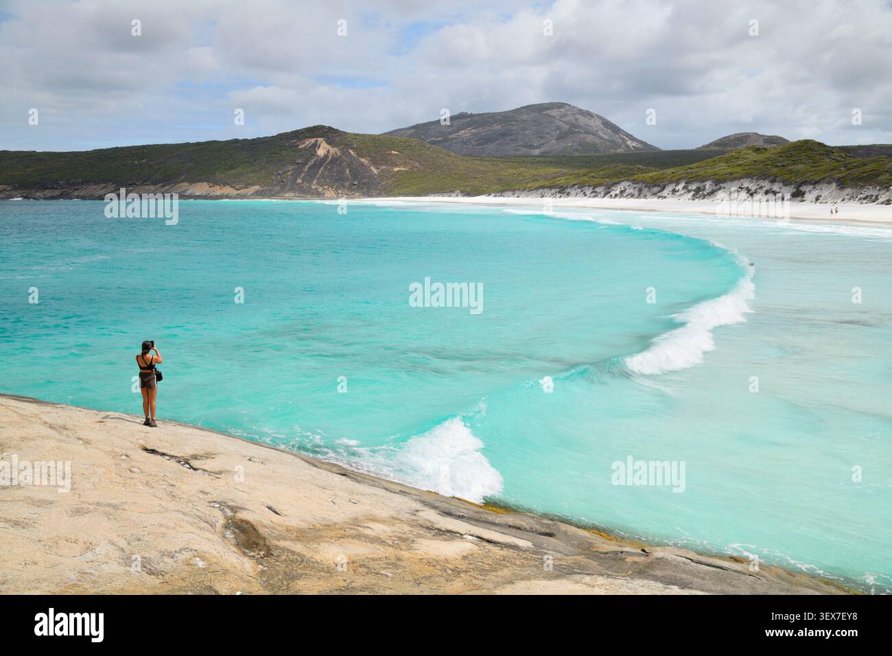 Australie, Australie occidentale, Esperance, Cape le Grand National Park, touriste photographiant les eaux turquoises de Hellfire Bay depuis un rocher de granit Banque D'Images