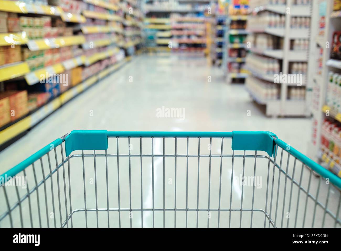 Gros plan de panier vide dans une épicerie avec des étagères de supermarché flues, des allées de produits Banque D'Images