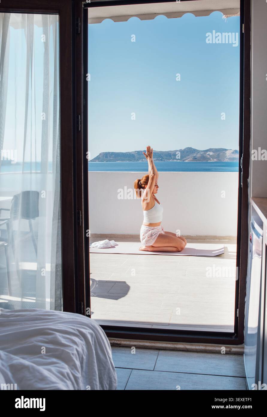 Femme d'âge moyen faisant du yoga du matin célèbre respiration anulom vilom pranayama Nadi shodhana ou exercices Kapalabhati de respiration de narine alternée sur la mer Banque D'Images