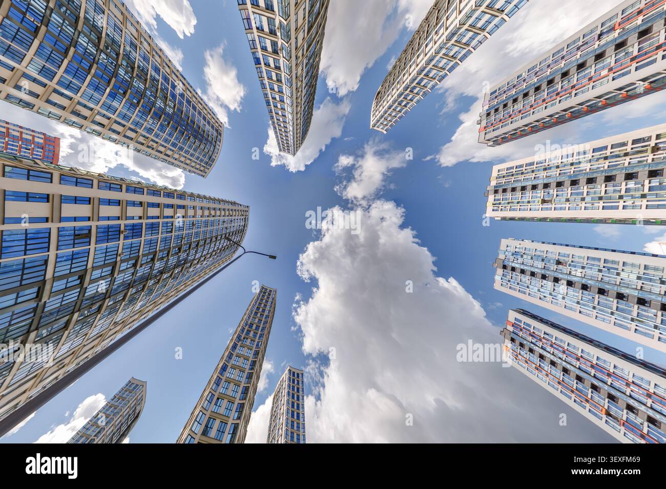 vue d'en bas dans le ciel bleu avec des nuages de grand complexe résidentiel de gratte-ciel moderne Banque D'Images