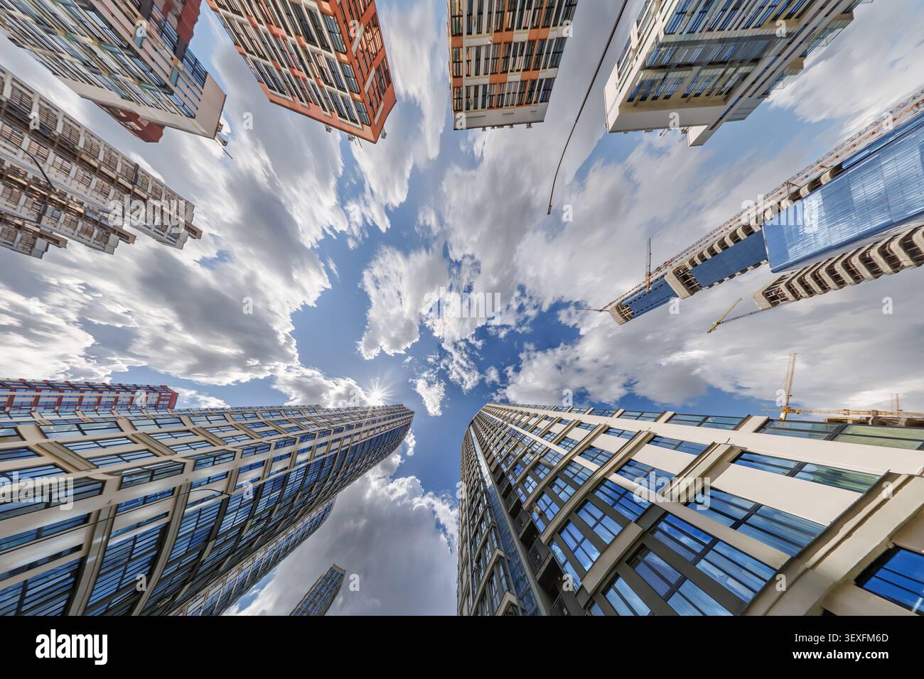 vue d'en bas dans le ciel bleu avec des nuages de grand complexe résidentiel de gratte-ciel moderne Banque D'Images